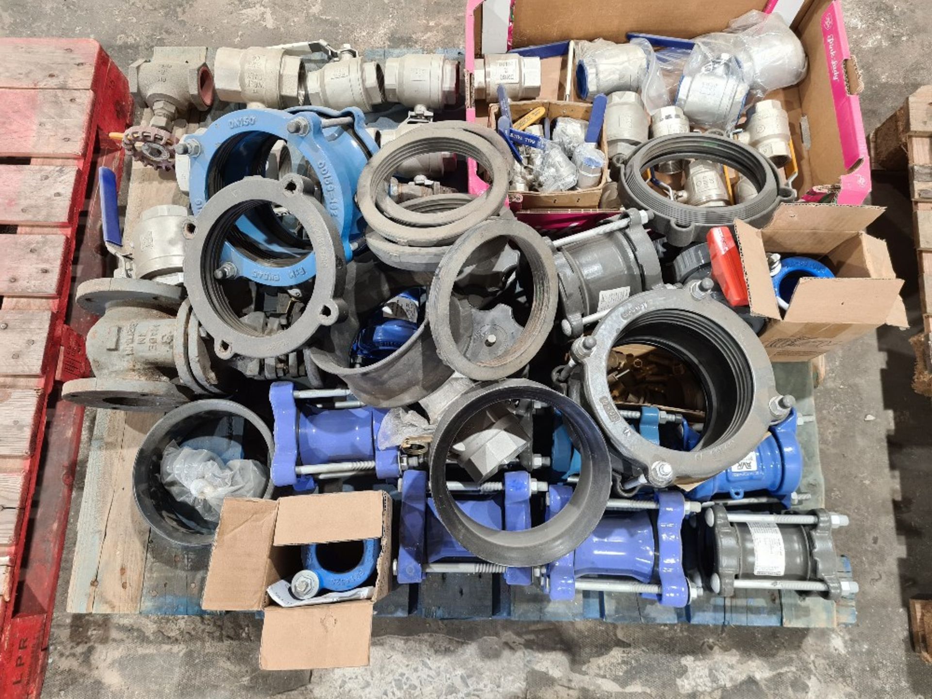 Pallet of isolation valves, pipe couplers and various items.