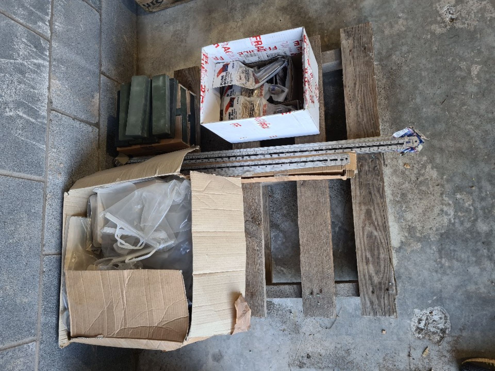 Pallet of misc goods incl new mini plasterer's hawks, oil stones, plumb bobs, aluminium rulers.