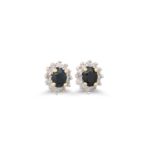 A PAIR OF DIAMOND AND SAPPHIRE CLUSTER EARRINGS, the oval sapphires to a diamond surround, mounted