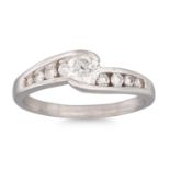 A DIAMOND SOLITAIRE RING, the central diamond to cross over style channel set shoulders, size L