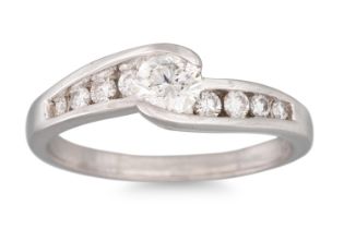 A DIAMOND SOLITAIRE RING, the central diamond to cross over style channel set shoulders, size L