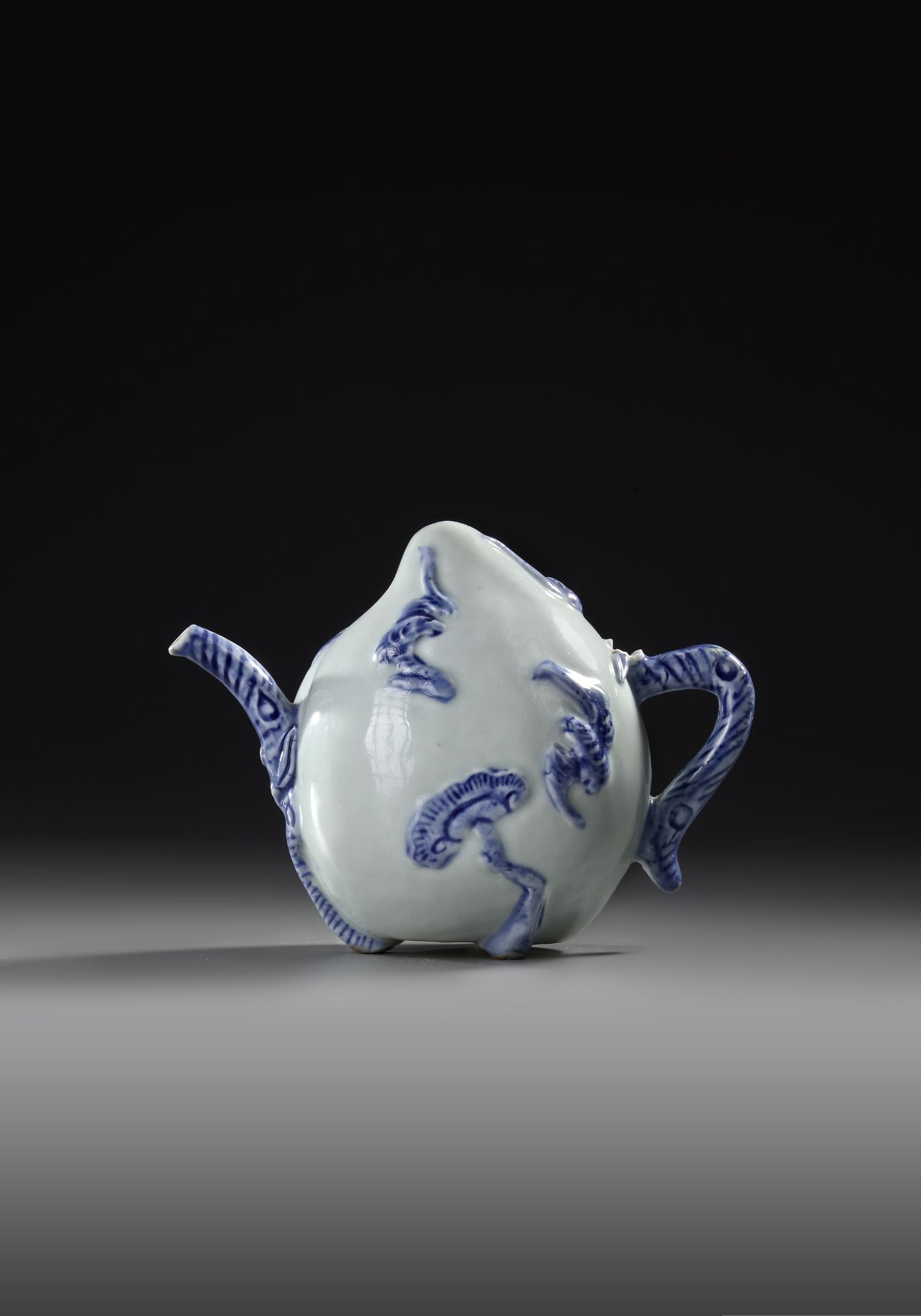 A CHINESE BLUE AND WHITE-GLAZED PEACH-FORM 'CADOGAN' TEAPOT, 19TH CENTURY