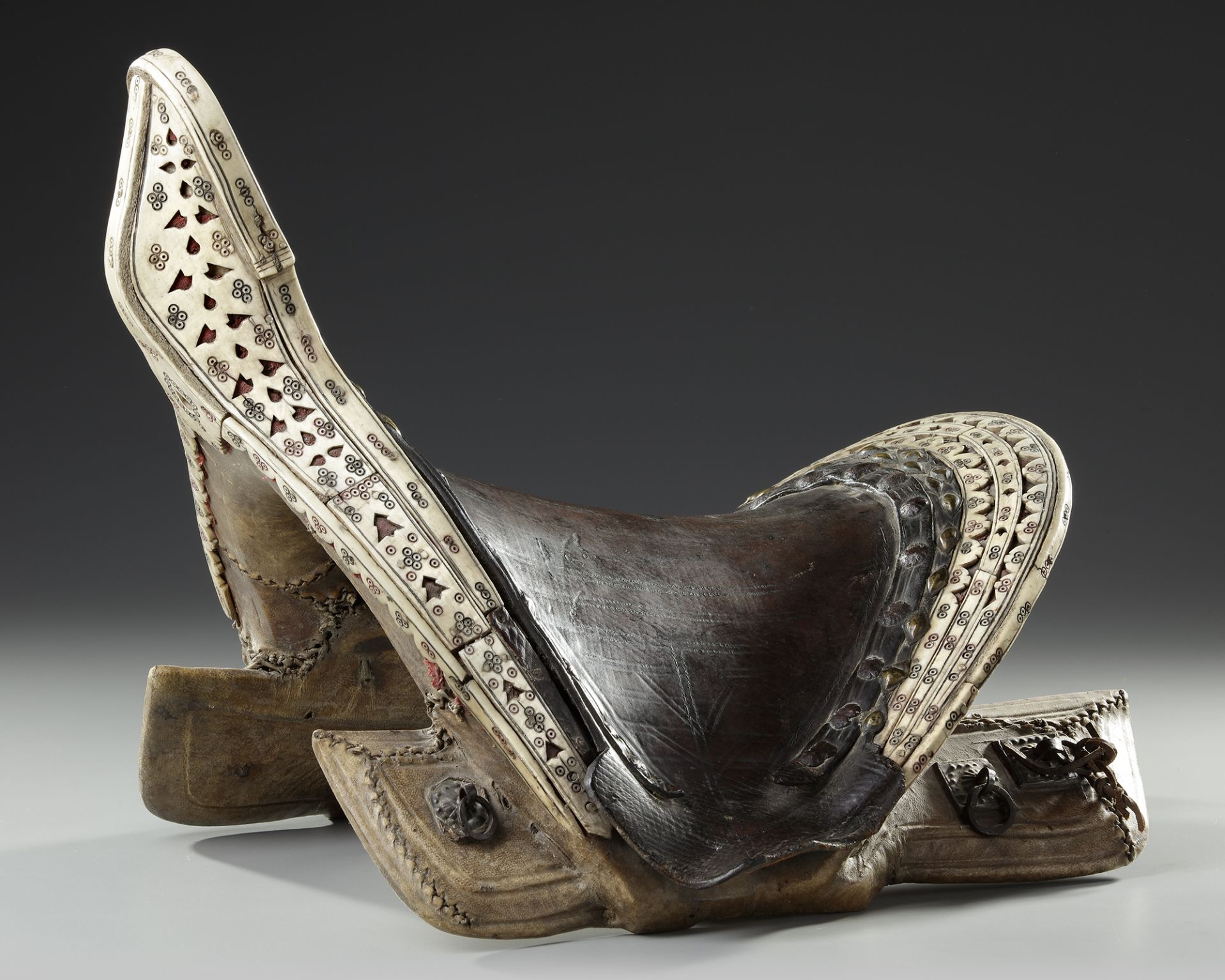 A FINE LEATHER COVERED WOODED SADDLE, CENTRAL ASIA, 19TH CENTURY