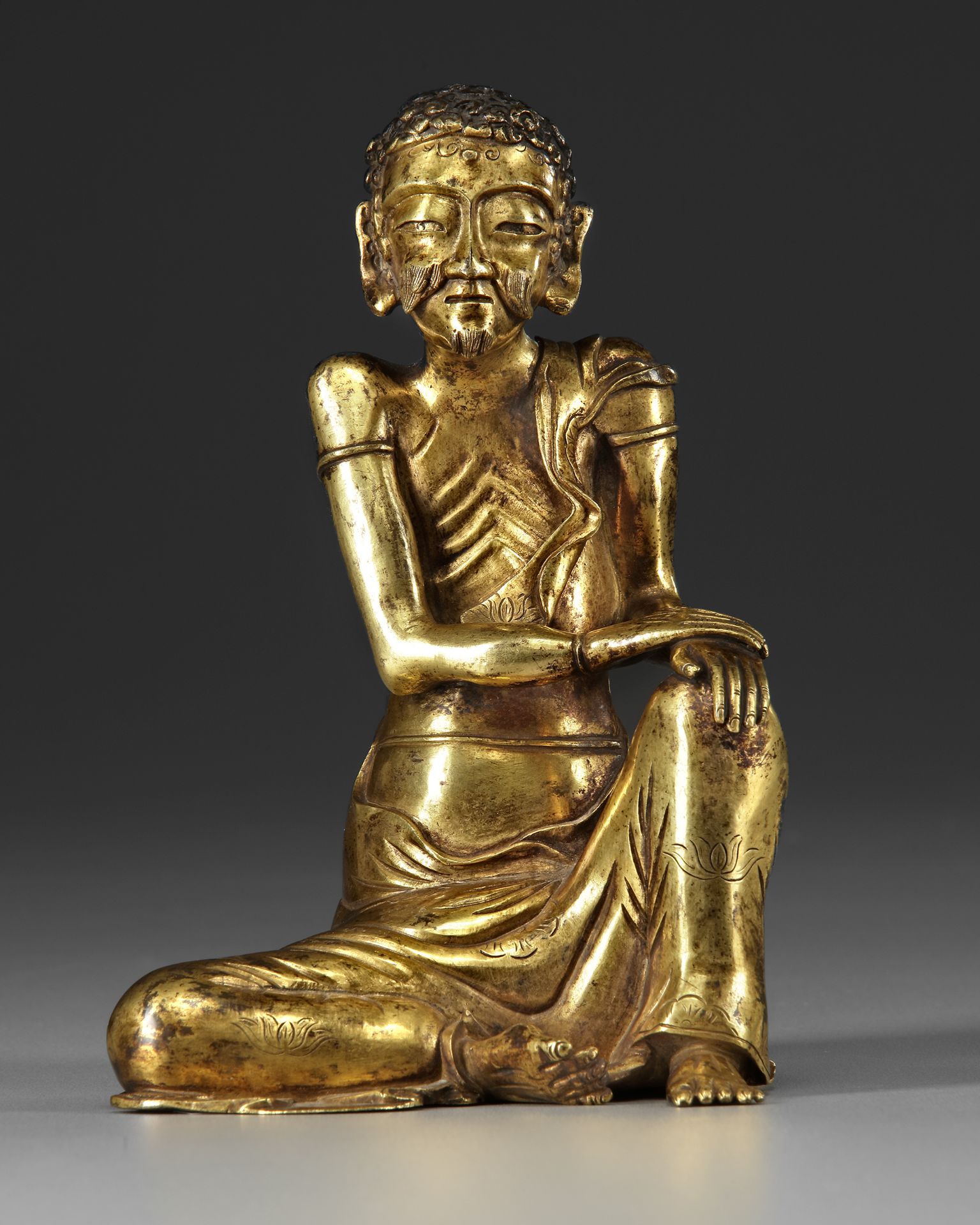 A GILT-BRONZE SEATED FIGURE OF THE ASCETIC SHAKYAMUNI, 17TH CENTURY