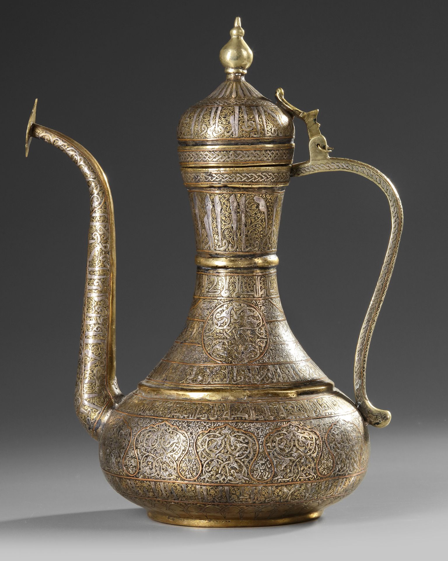 A FINE MAMLUK REVIVAL SILVER AND COPPER INLAID BRASS EWER, 19TH CENTURY