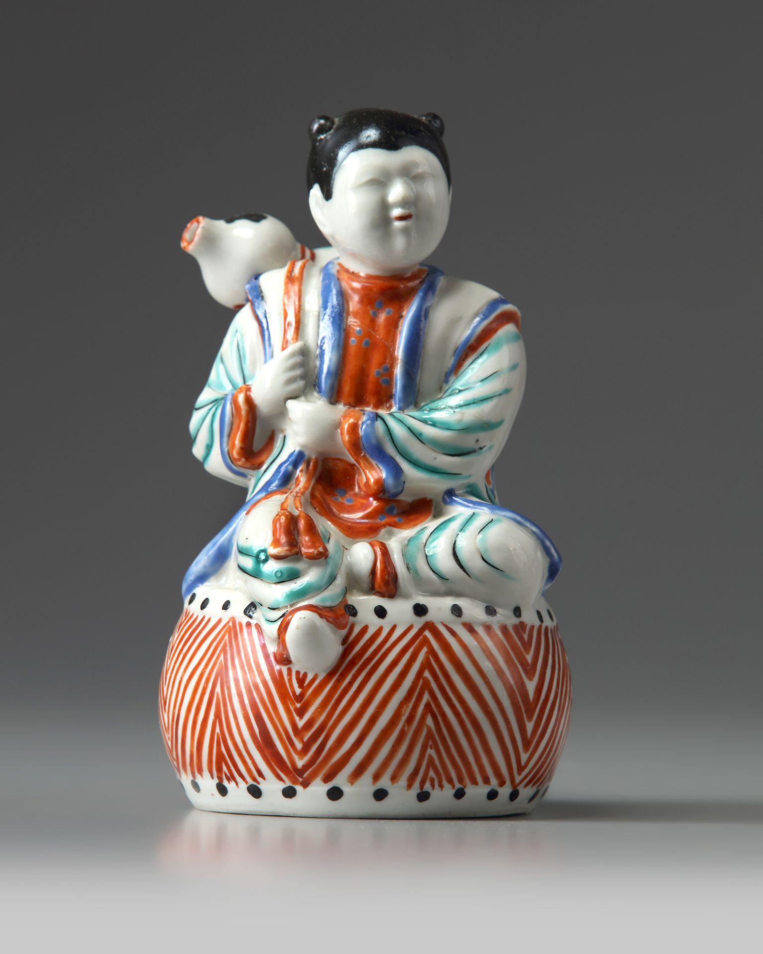 A JAPANESE FIGURE OF A BOY ON A DRUM, 1670-1690