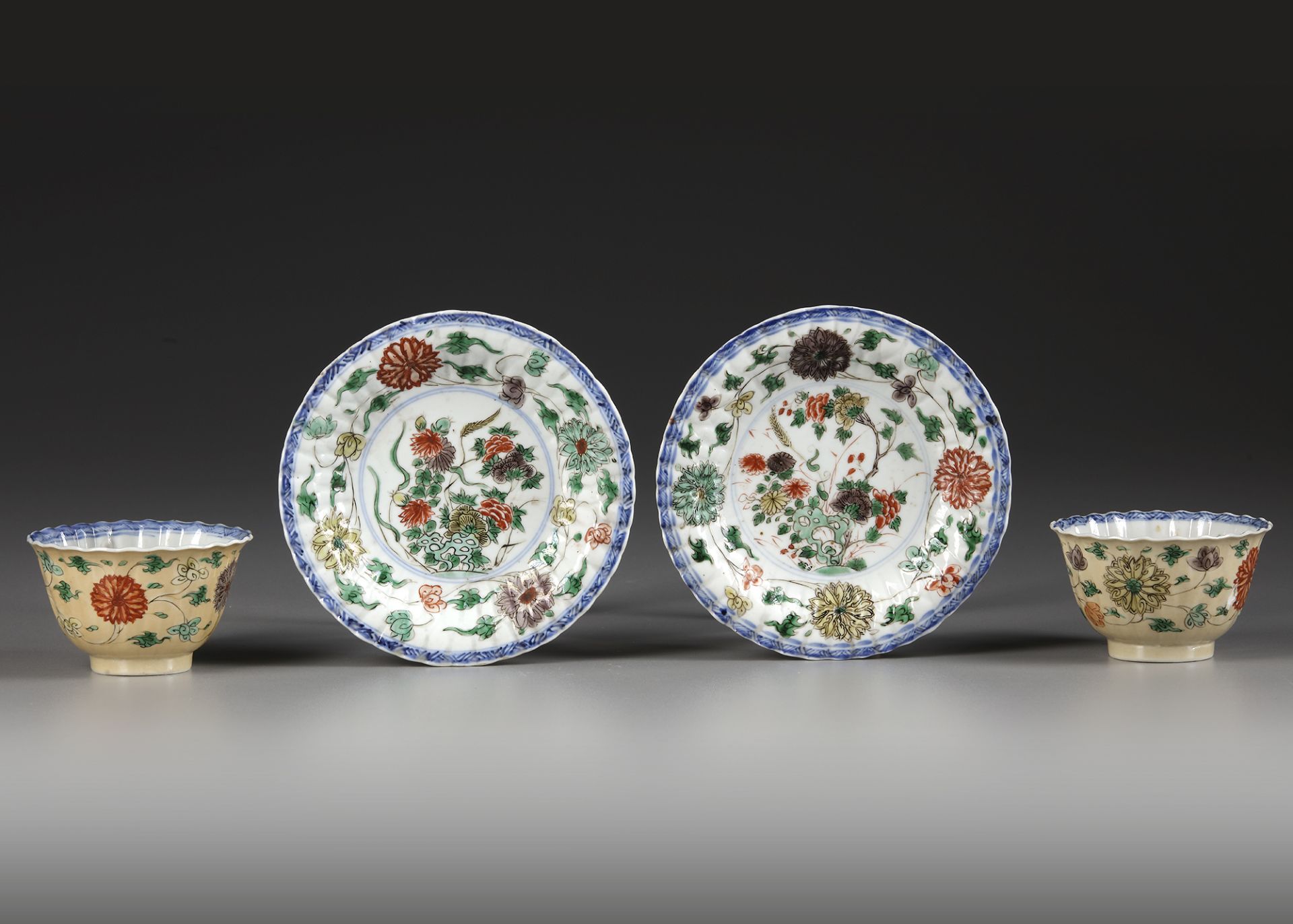 A PAIR OF CAFE AU-LAIT GROUND FAMILLE VERTE CUPS AND SAUCERS, KANGXI PERIOD (1662-1722)