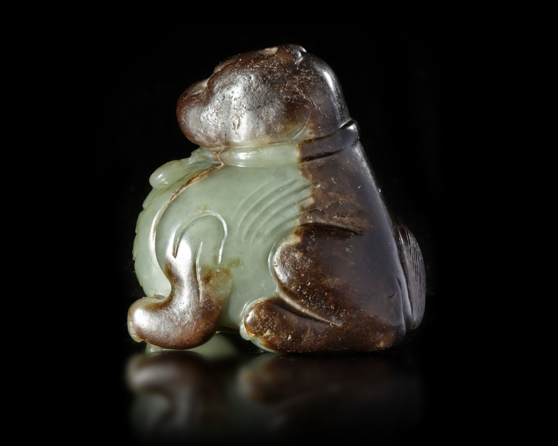 A CHINESE SPINACH CARVED JADE FU DOG, MING DYNASTY (1368-1644)