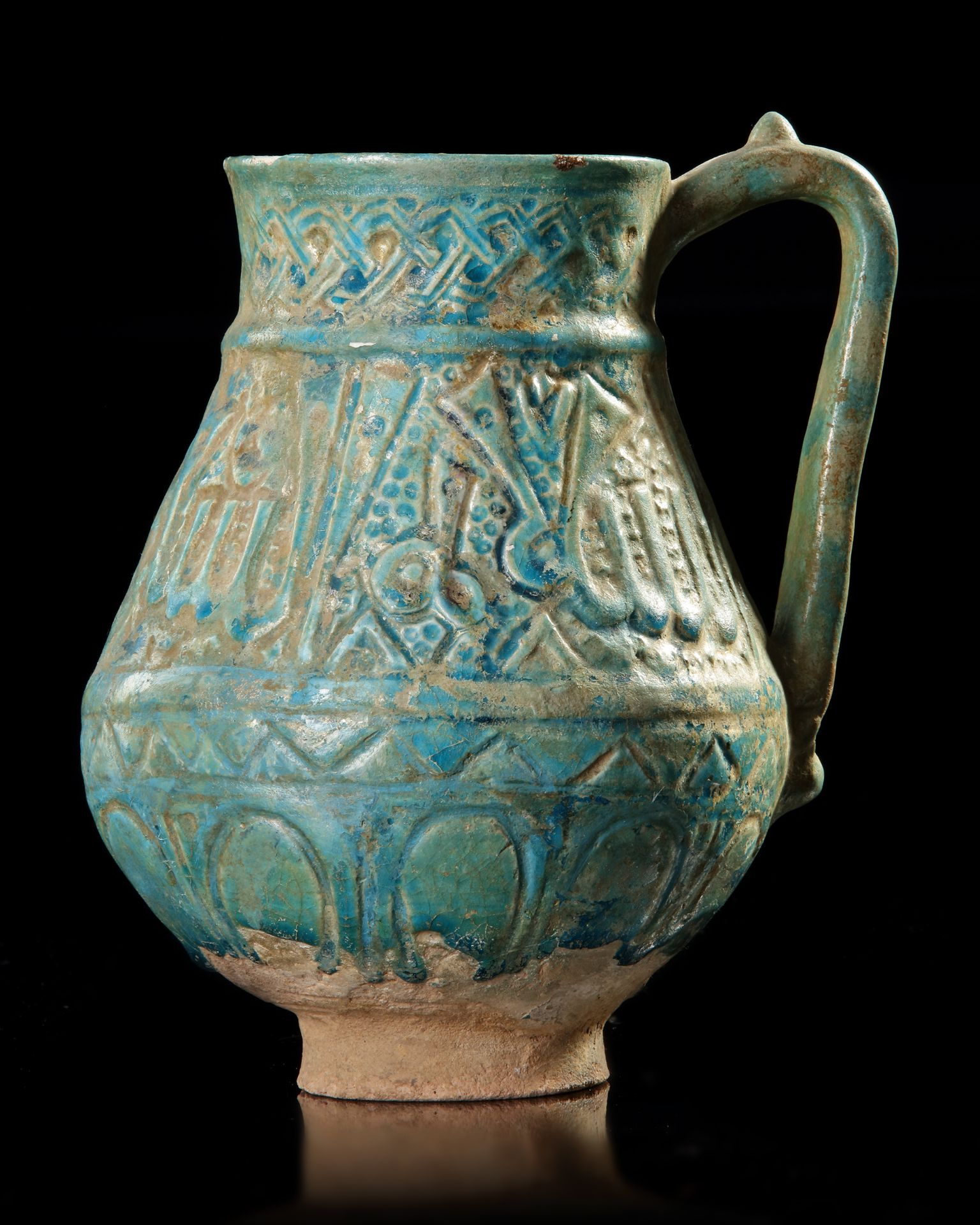 A TURQUOISE GLAZED POTTERY EWER, PROBABLY NISHAPUR, 12TH CENTURY