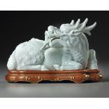 A CHINESE WHITE GLAZED SEATED DRAGON, QING DYNASTY (1644–1911)