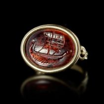 A ROMAN GARNET INTAGLIO SHOWING A SHIP SET IN A MODERN RING, 1ST CENTURY AD, RING 20TH CENTURY