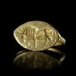 AN ARCHAIC GREEK GOLD RING WITH A BULL, CIRCA LATE 6TH CENTURY BC