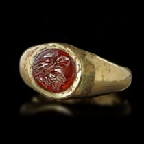 A HOLLOW ROMAN GOLD RING WITH A GARNET INTAGLIO OF AN EAGLE'S HEAD, 1ST CENTURY AD