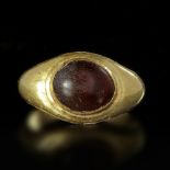 A HOLLOW ROMAN GOLD RING WITH A CABOCHON DARK BROWN CARNELIAN INSET, 1ST CENTURY AD