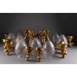 Quatre APPLIQUES à un bras de lumière et à décor de feuilles d'acanthe Bronze ciselé et doré, globe