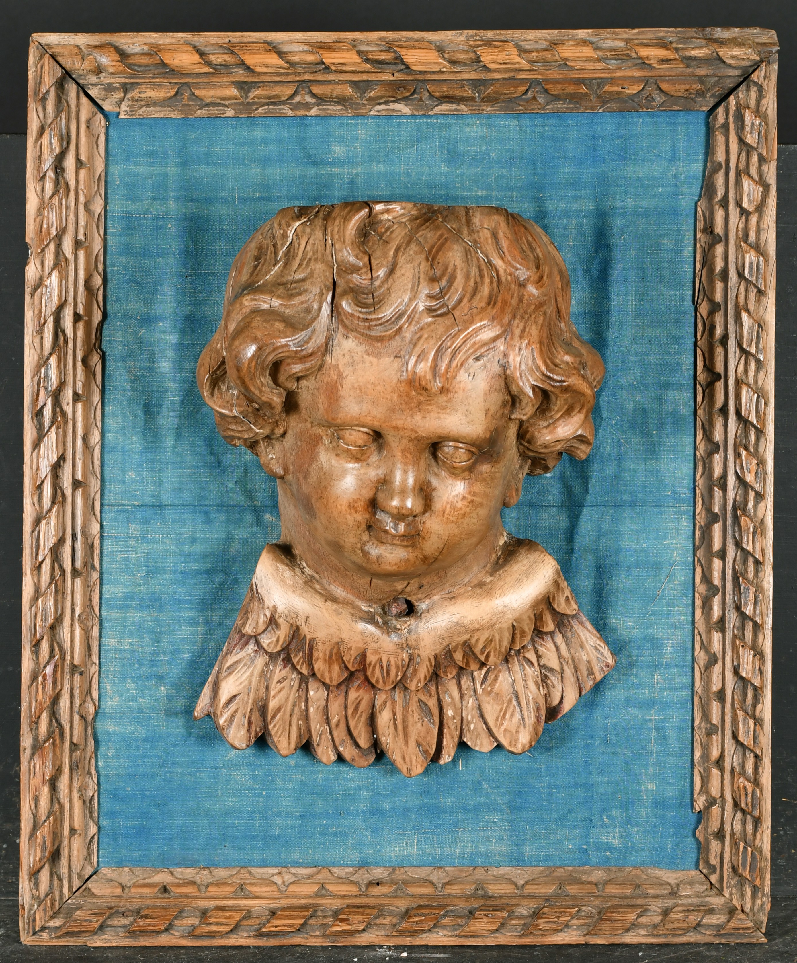 19th Century European School. A Winged Putto, Carved walnut on a blue silk backing within a carved - Image 2 of 4