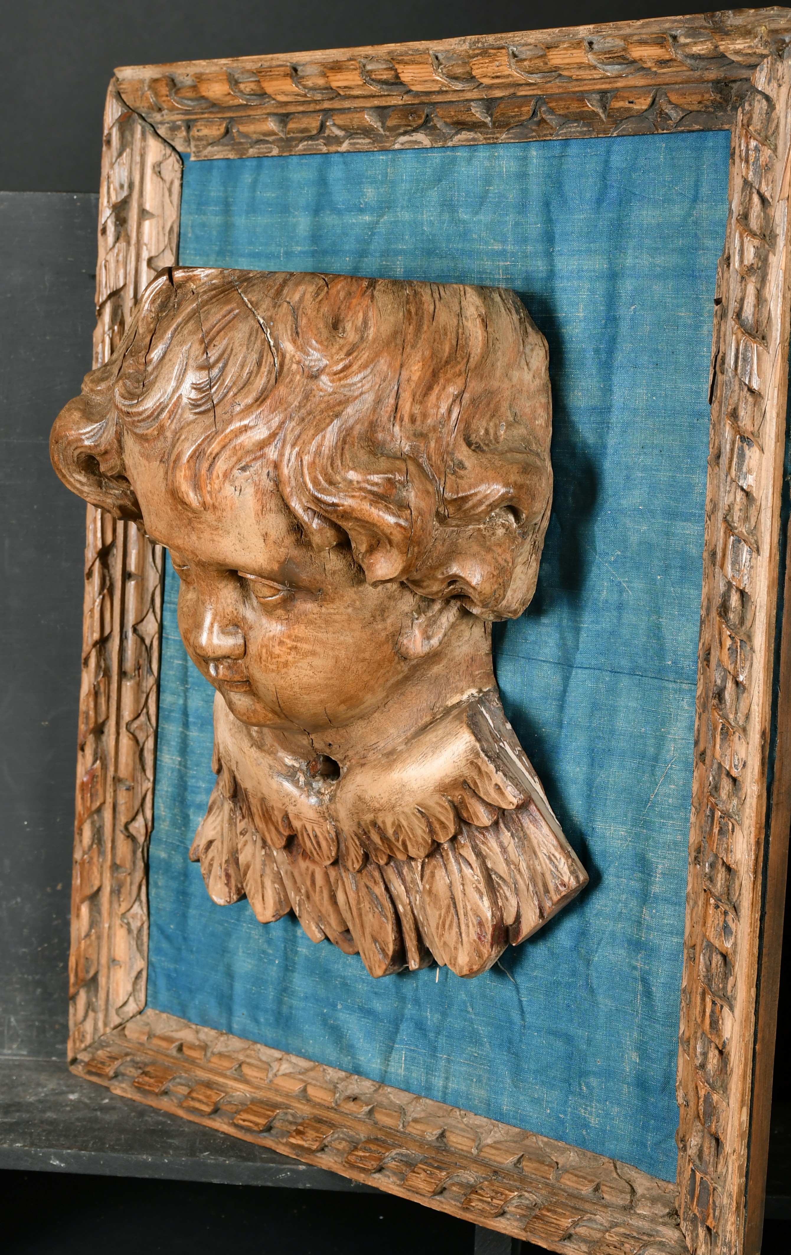 19th Century European School. A Winged Putto, Carved walnut on a blue silk backing within a carved - Image 3 of 4