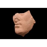 ETRUSCAN TERRACOTTA ACROTERION FRAGMENT OF THE FACE OF HERCLE
