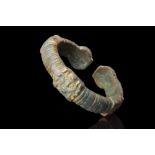 RARE HELLENISTIC BRONZE BRACELET WITH GODDESS AND MASKS FINIALS