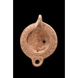 ROMAN TERRACOTTA OIL LAMP WITH A BUST OF MINERVA
