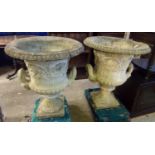 Pair of weathered composition campana shaped two handled pedestal garden urns, on square bases. 80cm