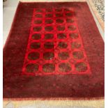 Middle Eastern design red ground carpet with a collection of central geometric medallions flanked by