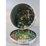 Cylindrical tin containing a large selection of glass multi coloured marbles. (B.P. 21% + VAT)