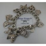 A silver charm bracelet with various charms including Prince of Wales Feathers, Horse, Holy Bible,