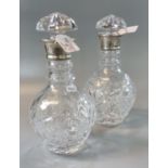 A pair of silver thumb and hob nail cut crystal decanters with silver collars, dated 1977, both with