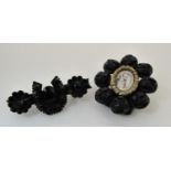 A Victorian black mourning brooch in 18th century style with central glazed panel depicting a