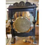 Early 20th century ornately carved brass and oak dinner gong on stand with striker. Height 105cm