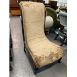 19th century ebonised and upholstered bedroom chair of low proportions on castors, in distressed