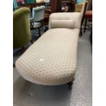 Late Victorian geometrically upholstered chaise-lounge on baluster turned tapering legs and castors.