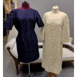 Two 1960's sleeved shift dresses; one blue with short sleeves and ribbon embroidery and a cream long