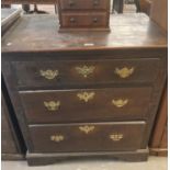 18th century oak straight front chest of three drawers on a projecting base and bracket feet.