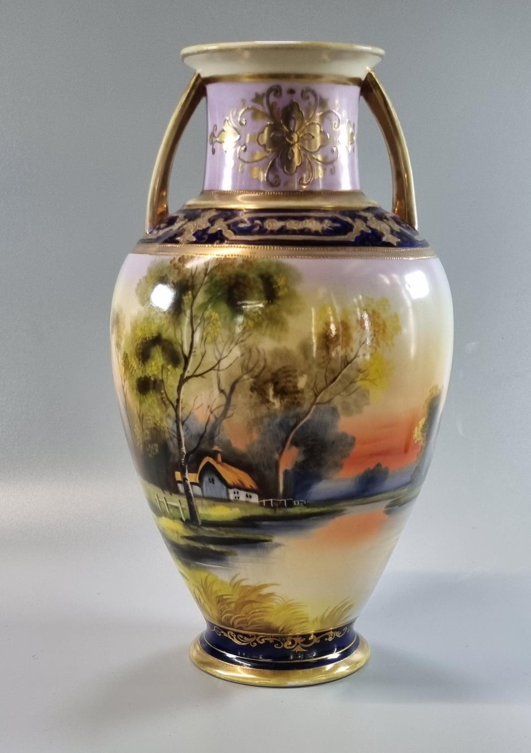 Noritake Japanese porcelain two handled baluster vase depicting rural lake and cottage scene. Height