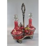 Early 20th Century silver plated and cranberry glass cruet set comprising: two decanters with