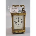 Early 20th century brass carriage clock with serpentine case and full depth ceramic Roman face