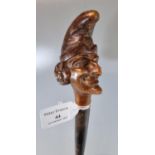 Vintage probably 19th century Mr Punch type carved wooden stick doll with turned stem. 44cm long