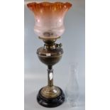 Early 20th century double oil burner lamp having frosted orange etched floral shade with a brass