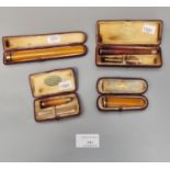 Plastic tub containing four cased gold and amber cheroot holders. (B.P. 21% + VAT)