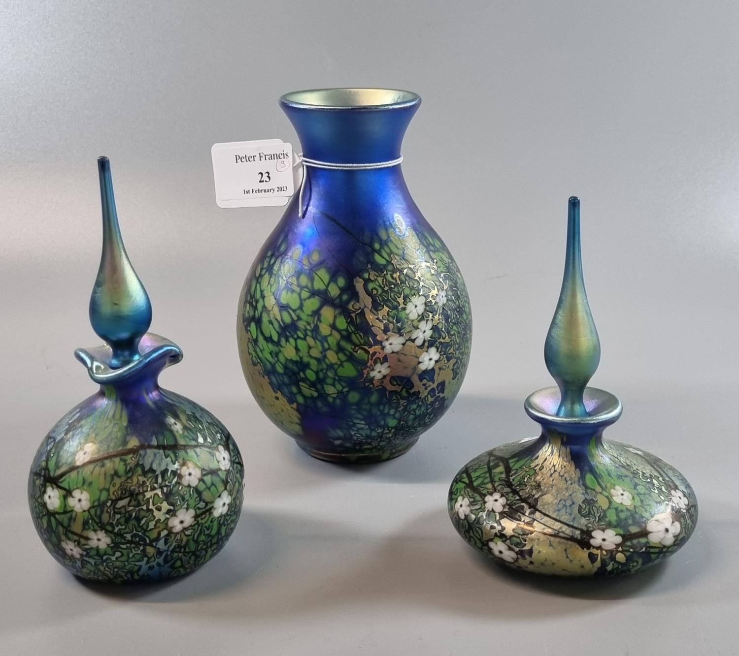 Collection of modern Okra art glass on a blue ground, decorated with flowers and foliage, to