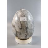 A large and very heavy grey veined marble 'egg'. On display stand. 19cm high approx. (B.P. 21% +