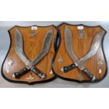 Two pairs of Gurkha Kukri knives on wooden shield shaped plaques. (B.P. 21% + VAT)