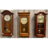 Three modern mahogany finish and oak wall clocks; one three train movement marked 'Hermle', the