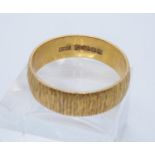 22ct gold bark finish wedding ring. Size U + 1/2, 7.7g approx. (B.P. 21% + VAT)