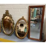 Two modern gilt ornately framed oval mirrors together with another modern framed rectangular mirror.