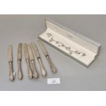 Set of six silver handled dessert knives with steel blades, together with a silver charm bracelet,