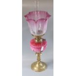 Early 20th Century double oil burner lamp having cranberry frosted glass shade above a pink floral