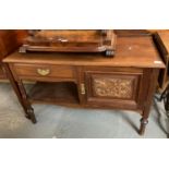 Edwardian mahogany side table, having gallery top above ornately carved door on turned supports. (